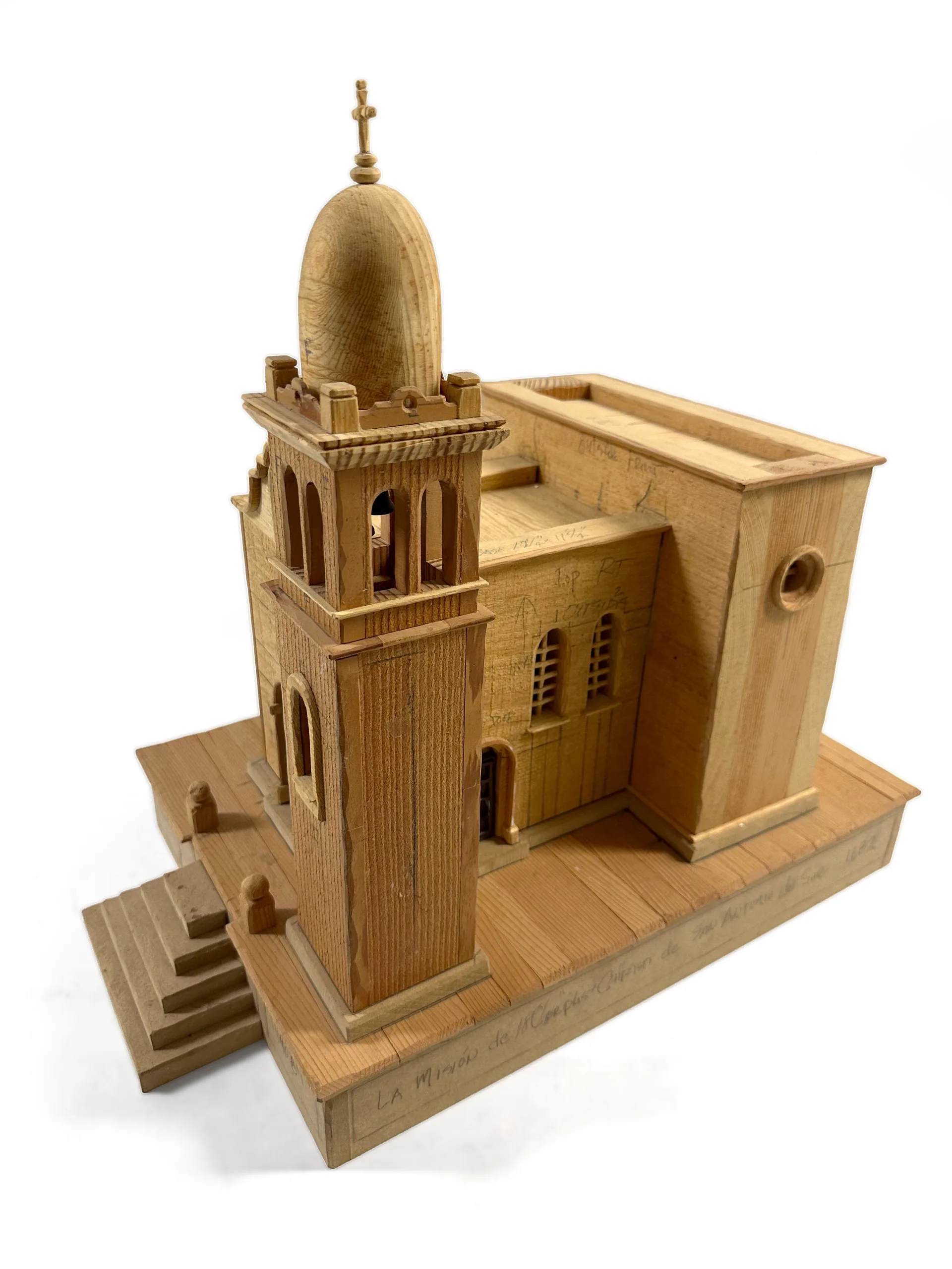 The unpainted pine mission sculpture from the side, its exposed joinery showing how the piece was made.